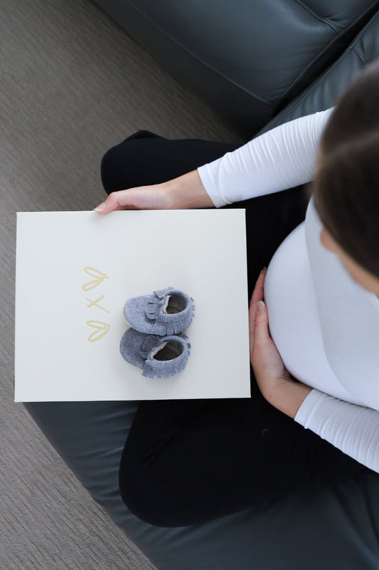 Expectant mum looking at keepsake folder to enter pregnancy and baby milestones